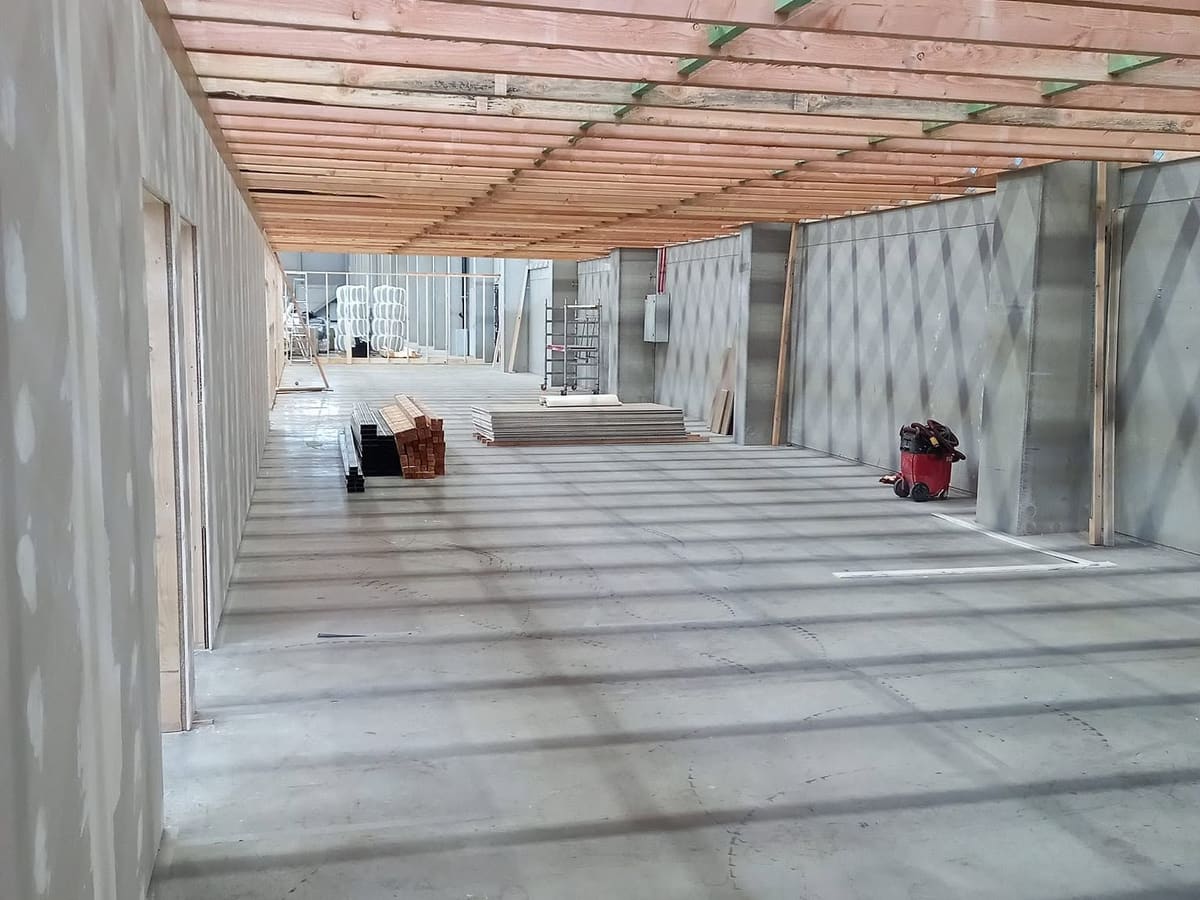 Solivage bois du plancher de l'étage créé au-dessus des locaux, ossatures habillées en panneaux de part et d'autre du passage